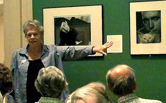 Melinda Hope talking to a crowd about pictures on a wall