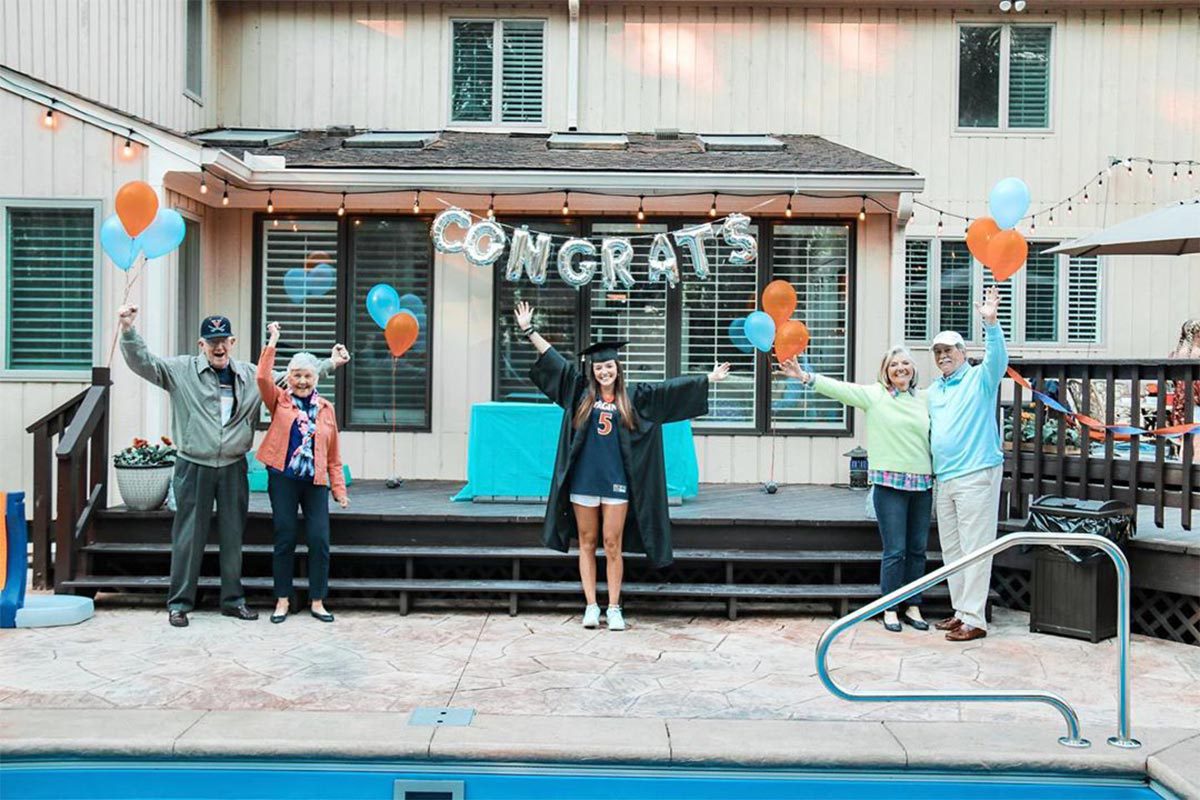 Graduate Abby Bostian’s  socially distanced with her family celebrate her graduation at a backyard celebration
