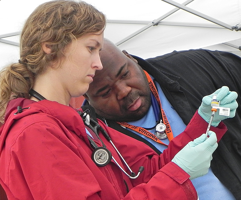 Hershaw Davis Jr., right, works with medical student Emily Kinsey, left, to draw up an injection
