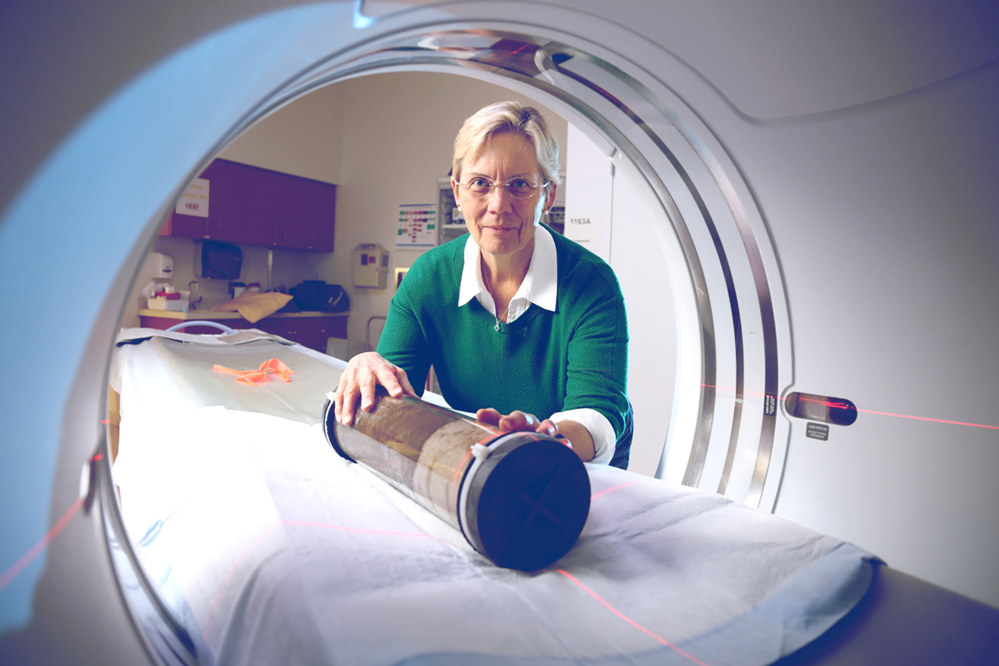 Linda Blum placing a tube full of stuff into a CT scan 