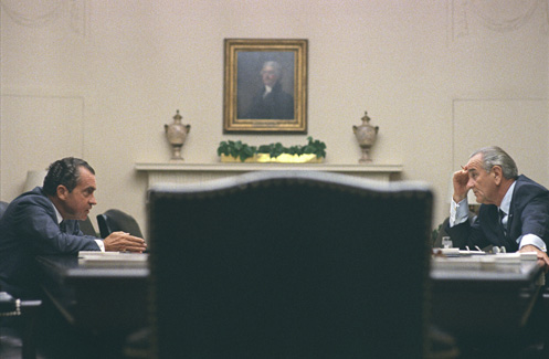Richard Nixon, left, sits across from Lyndon B. Johnson, right, at a table