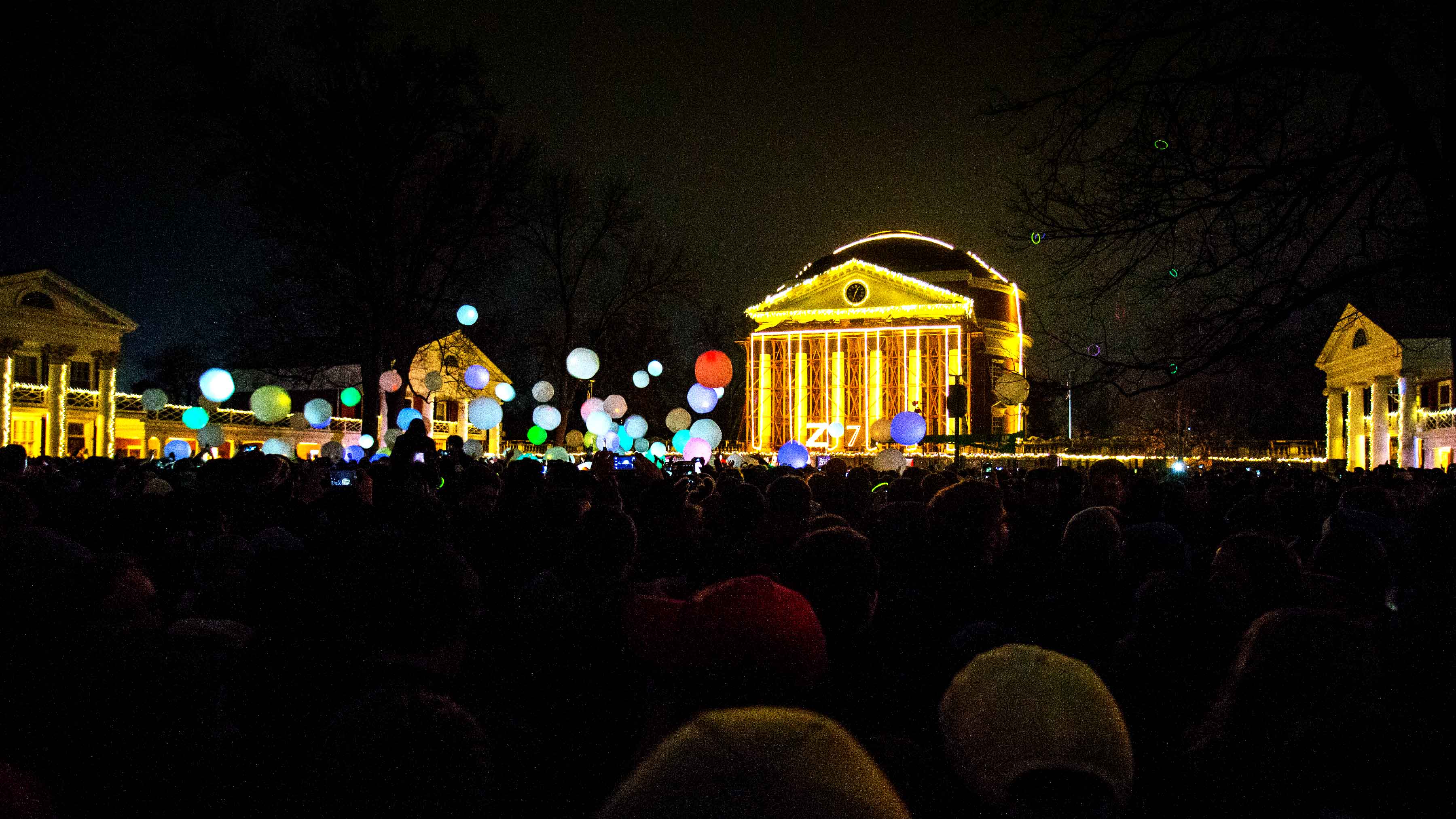 The Lawn full of people wearing lighted necklaces, hitting lit up balls, with the rotunda all lit up in the background