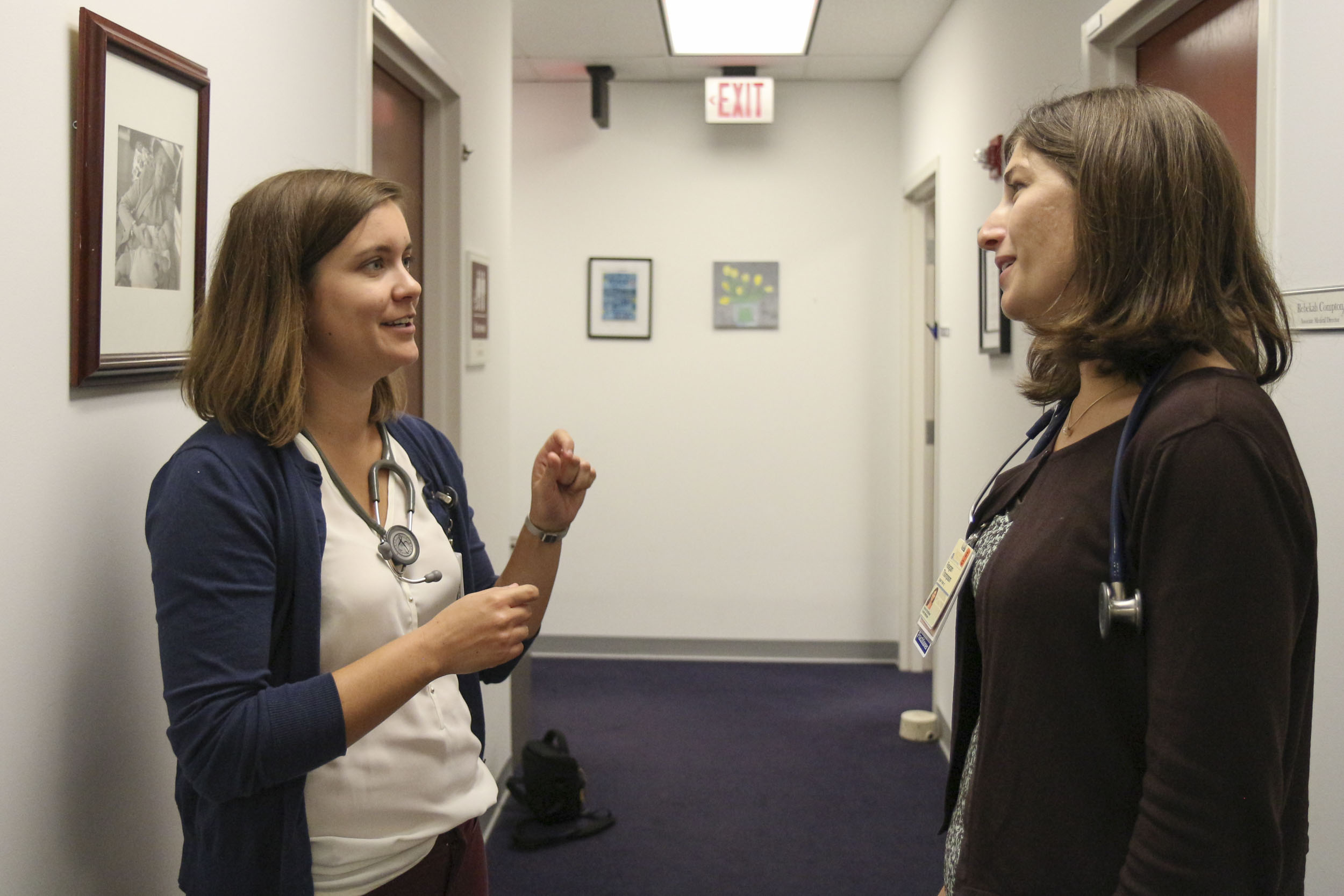 Maggie Spriggs, left, chats with  Reagan Thompson, right, in a hallway