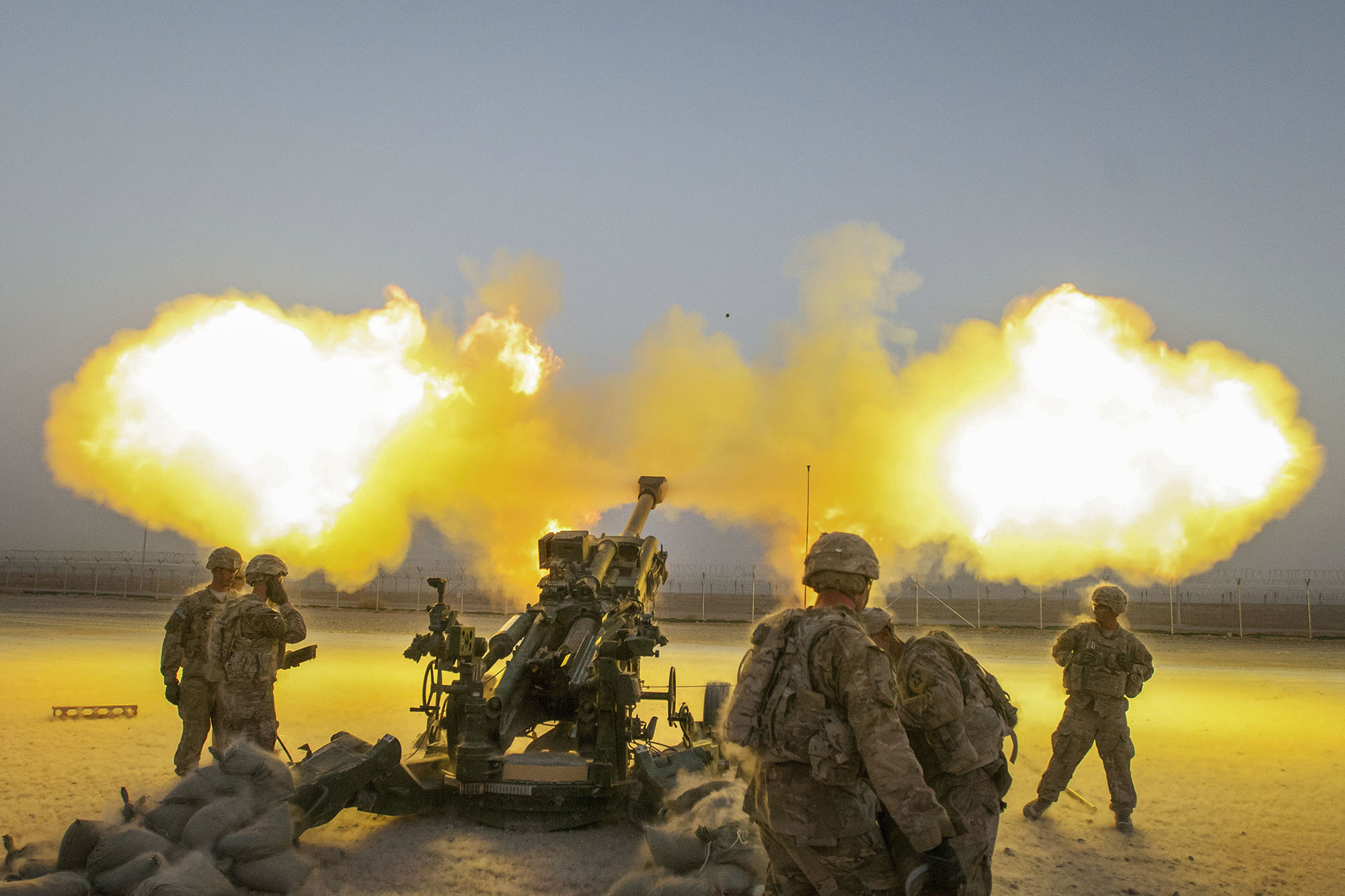 US Service Men firing a cannon on a training field