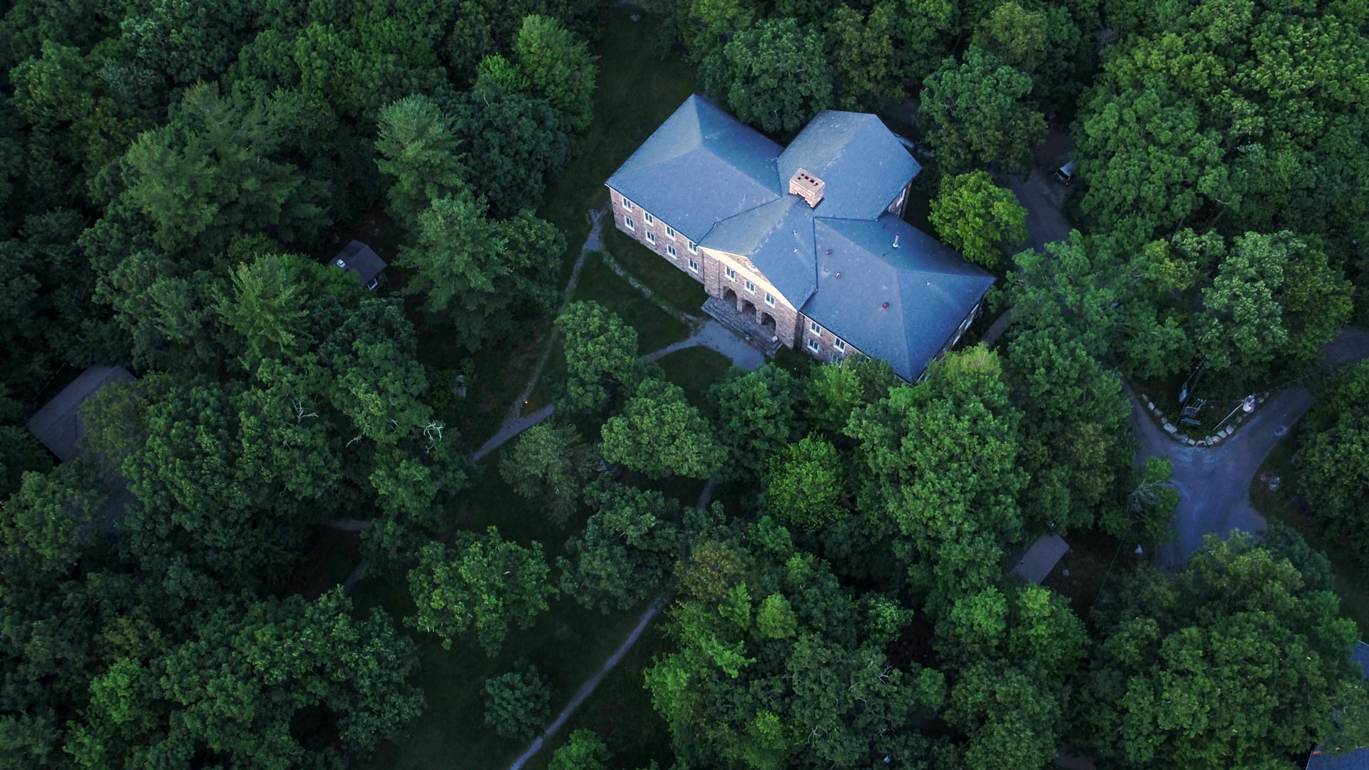 Aerial view of a two story brick house surrounded by trees