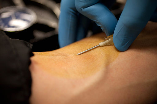 Needle being stuck into a persons arm to draw blood
