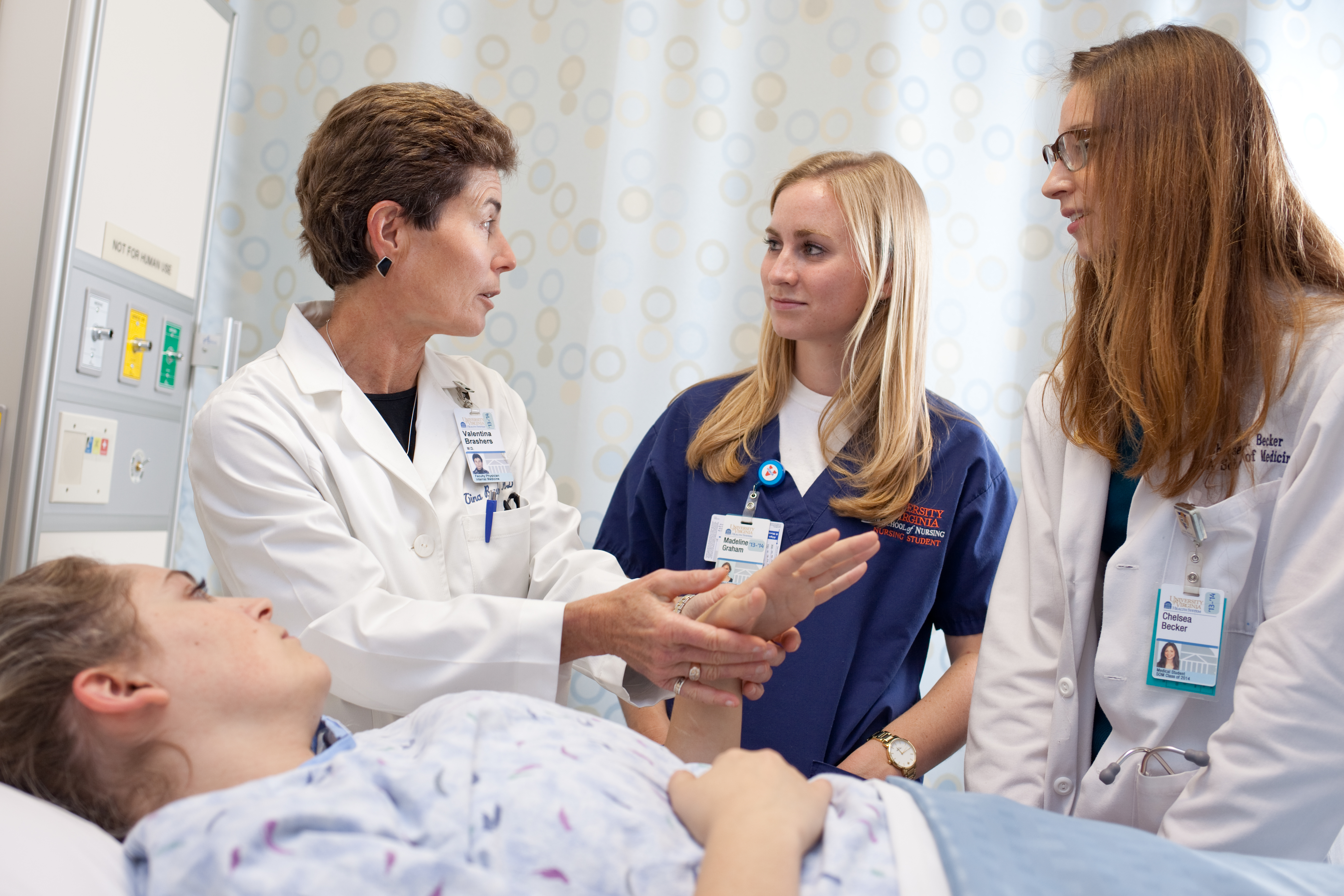 Dr. Valentina Brashers  works with two nursing students and a patient