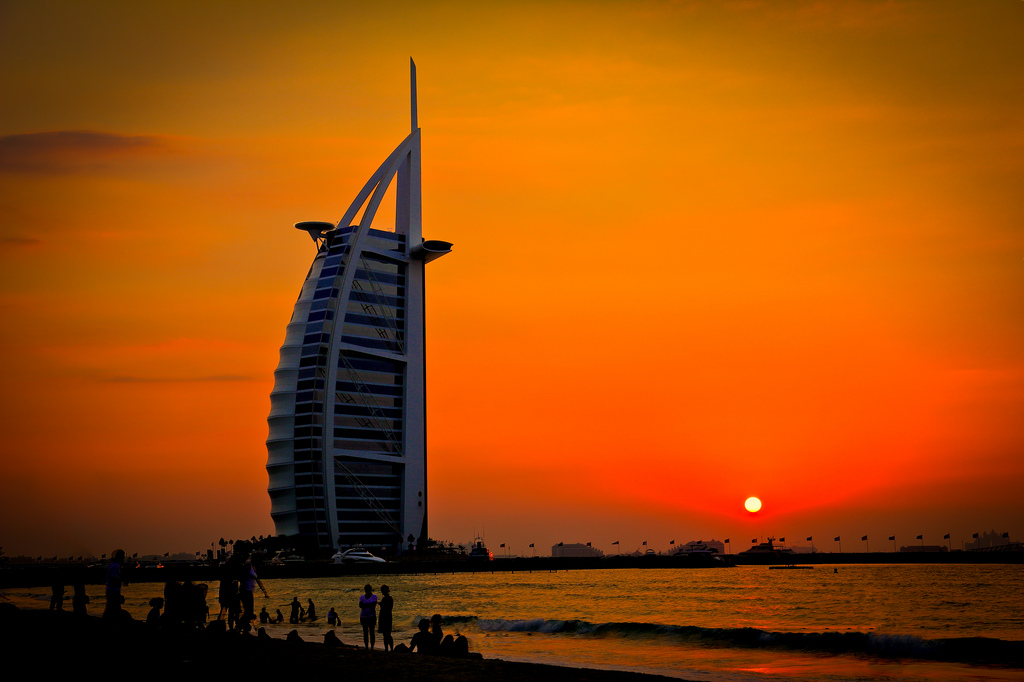 The Burl al-Arab hotel in Dubai as the sun goes down creating a bright red and orange sunset
