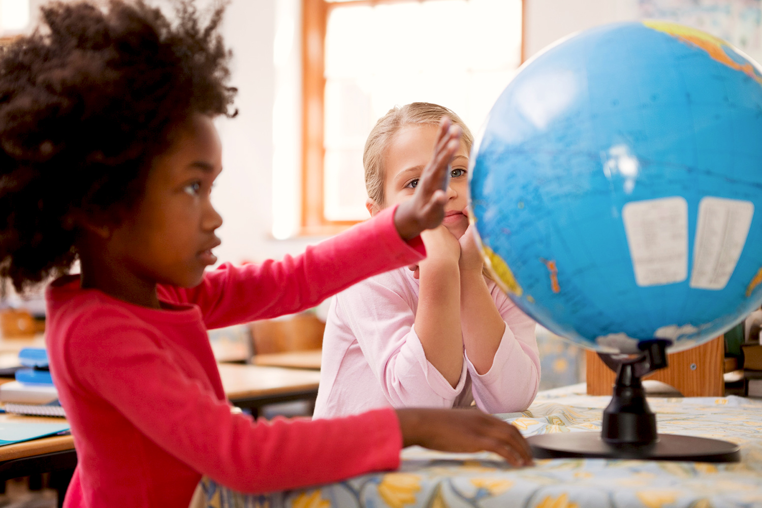 Children playing with a globe on a table