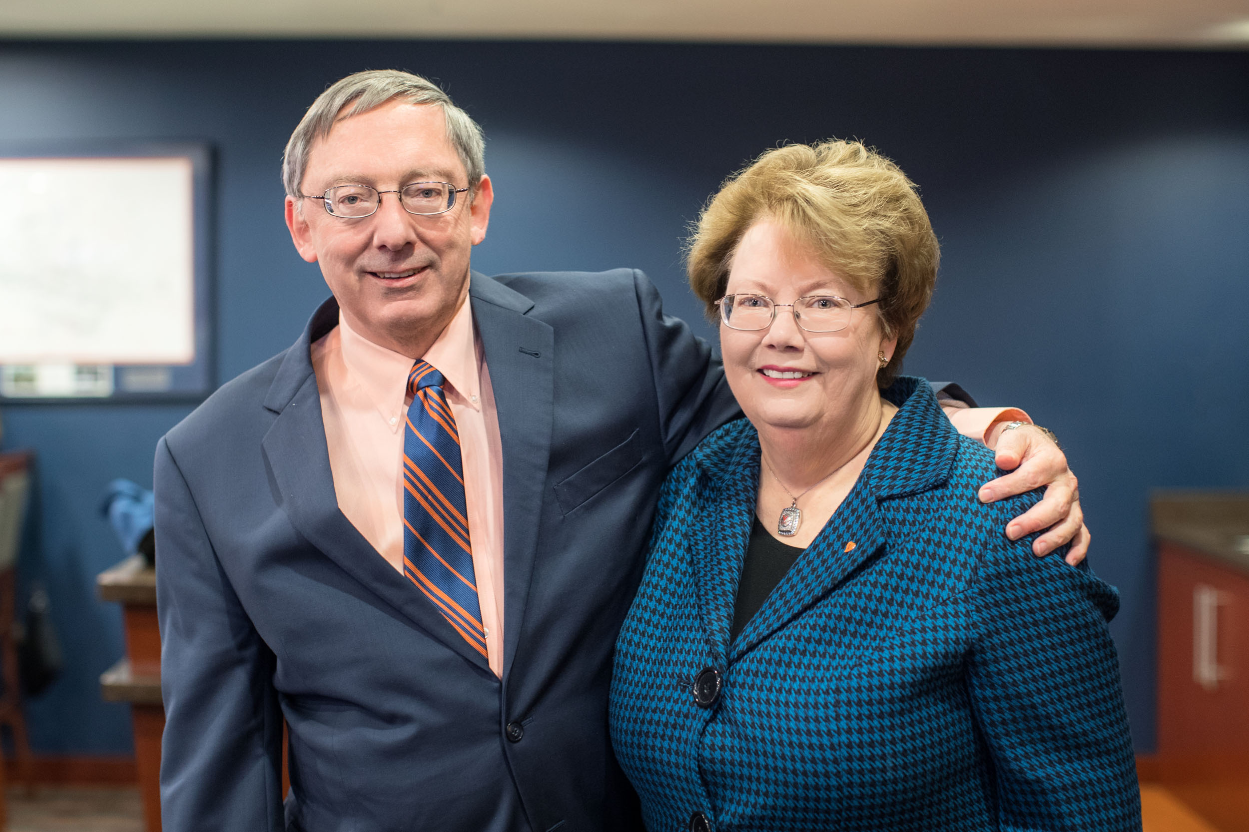 UVA President Teresa A. Sullivan and her husband, Douglas Laycock, stand together smiling at the camera
