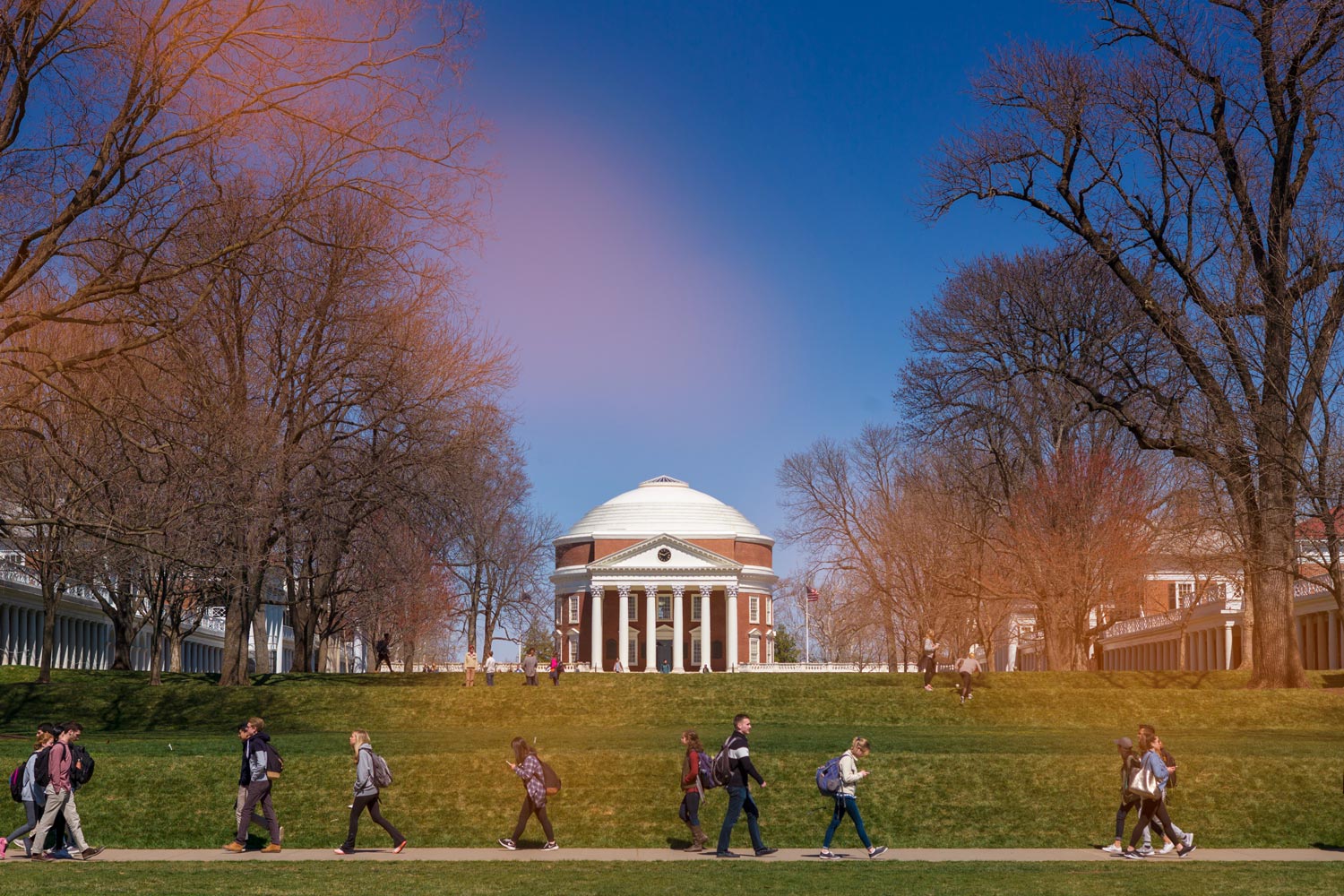 Students walk on a sidewalk on the Lawn with a backdrop of the Rotunda