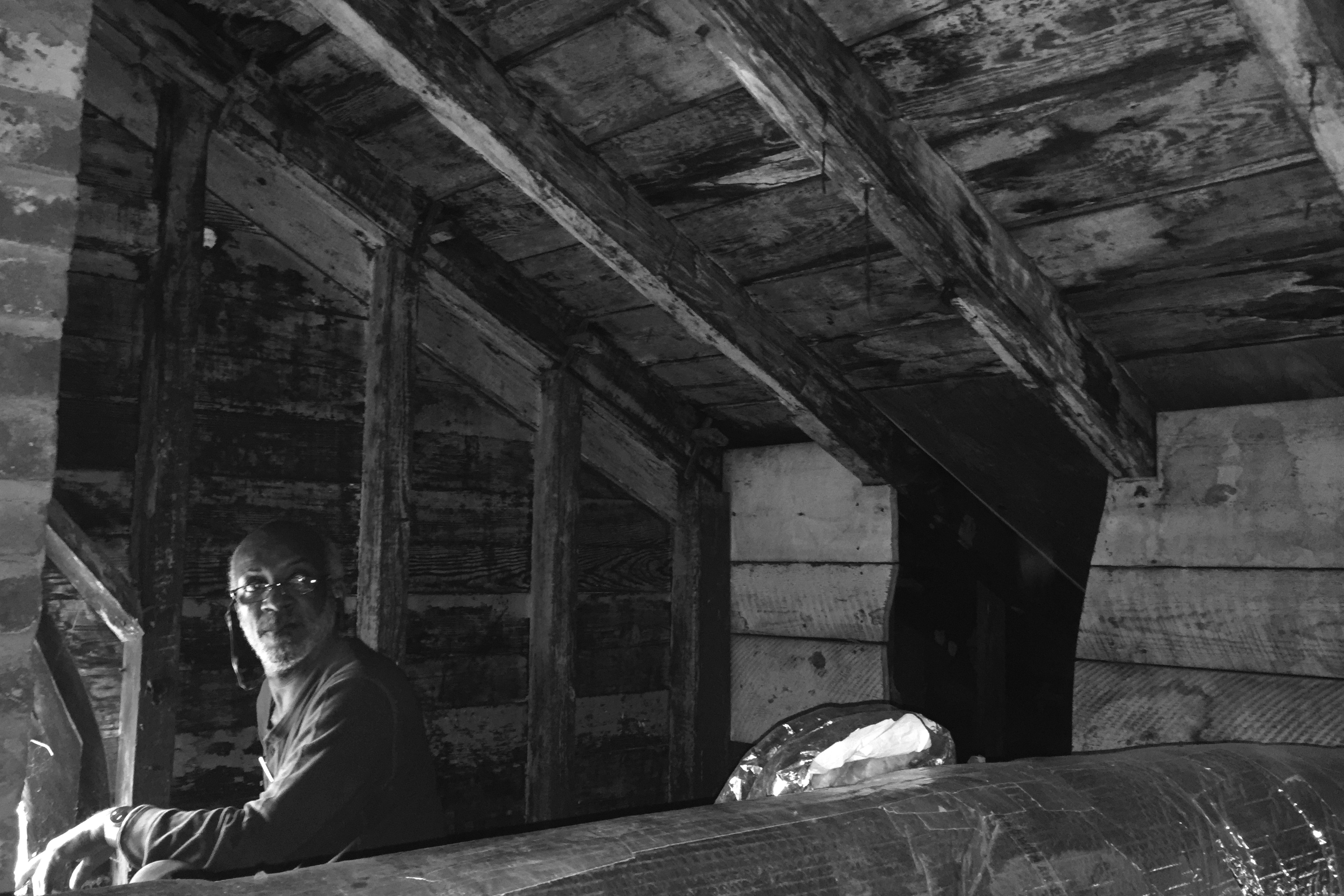 Peter Giscombe sits in a dark attic