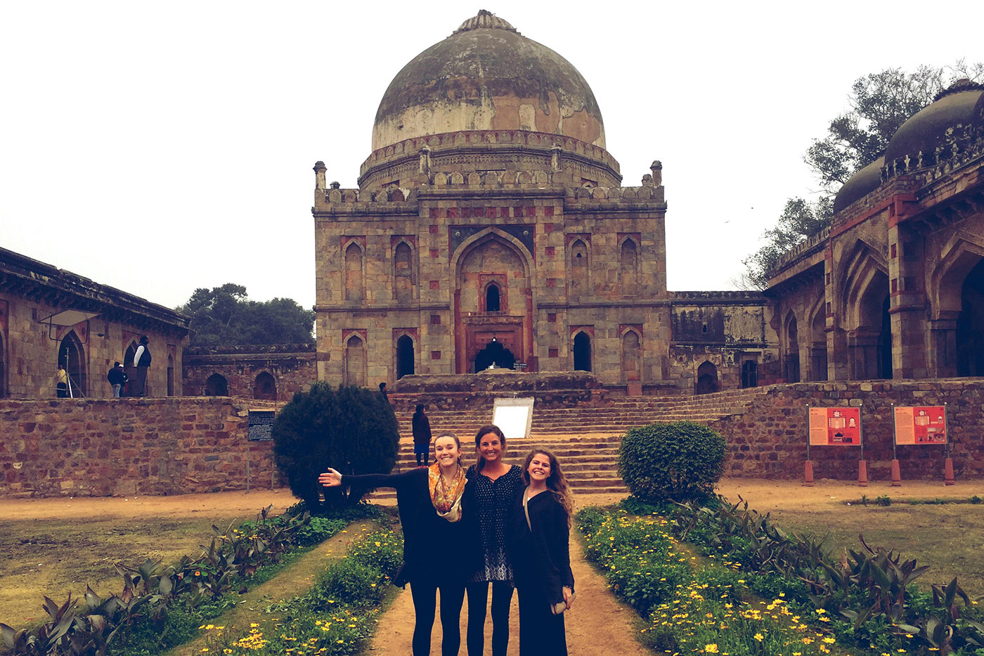 A trio of students stand together for a photo during their visit to the Old Fort in New Delhi.