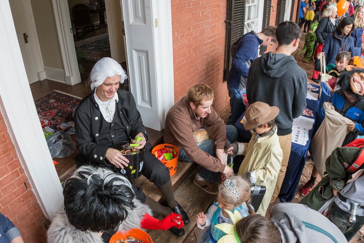 Students hand out candy to trick-or-treaters on the Lawn