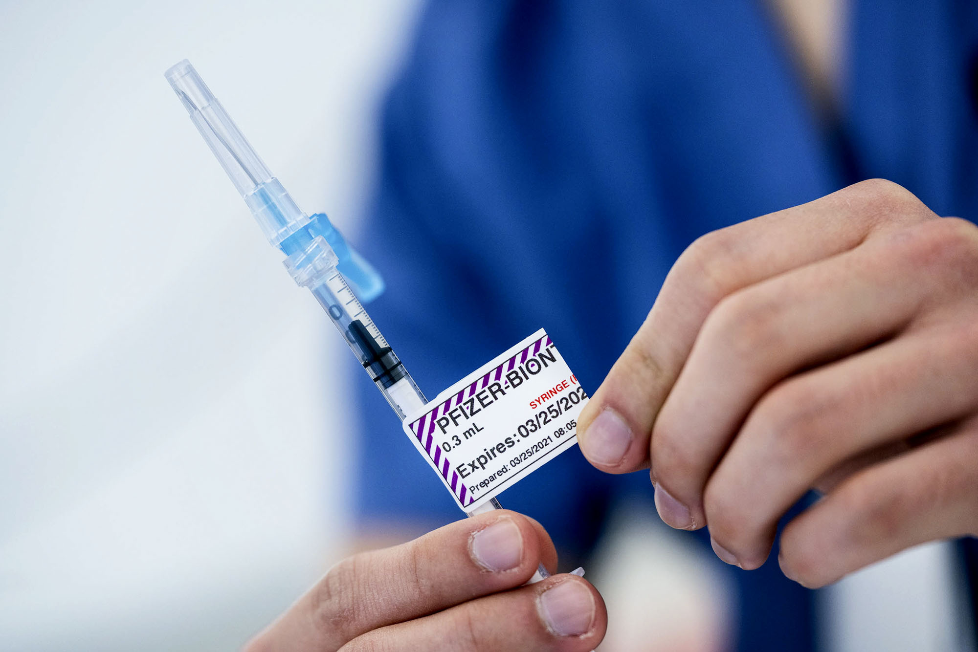 UVA health member holding a prefilled Pfizer syringe 