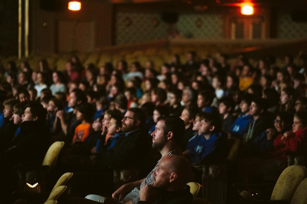 large crowd watching a film in a theatre