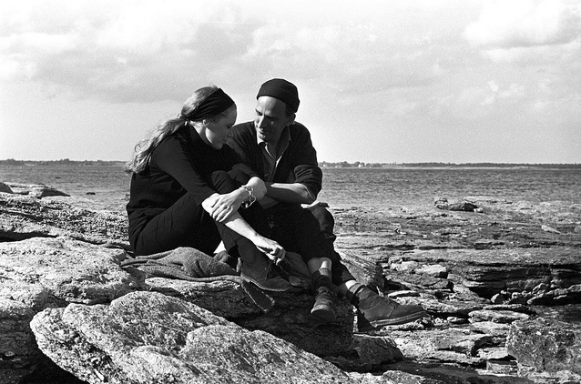 Two people sitting on rocks talking
