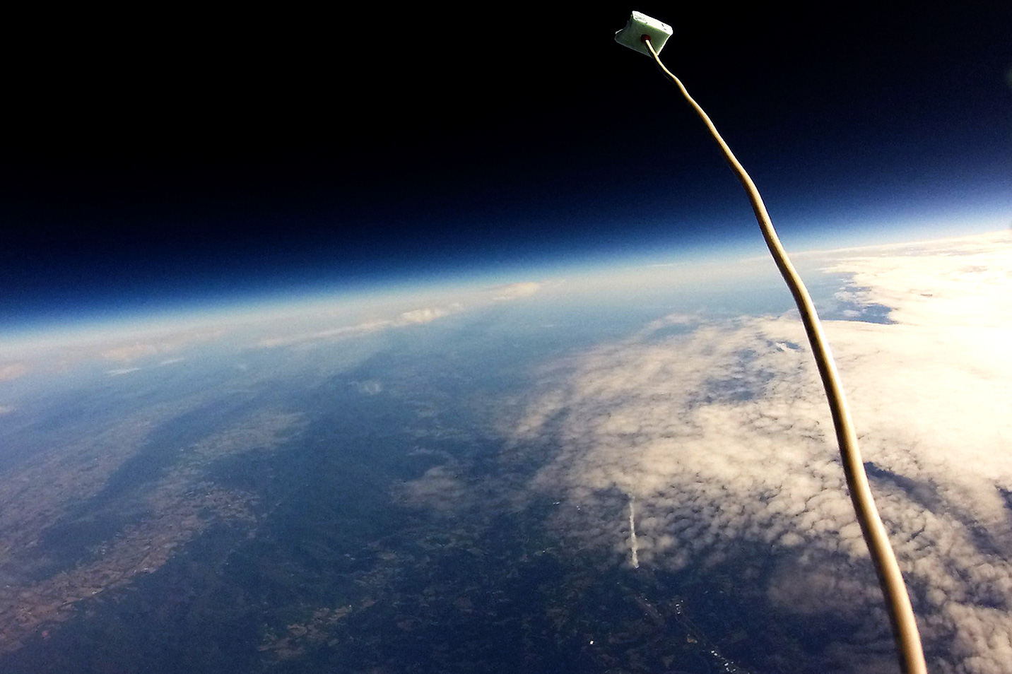 A view from a camera aboard the payload of the high-altitude weather balloon looking over the earth from space