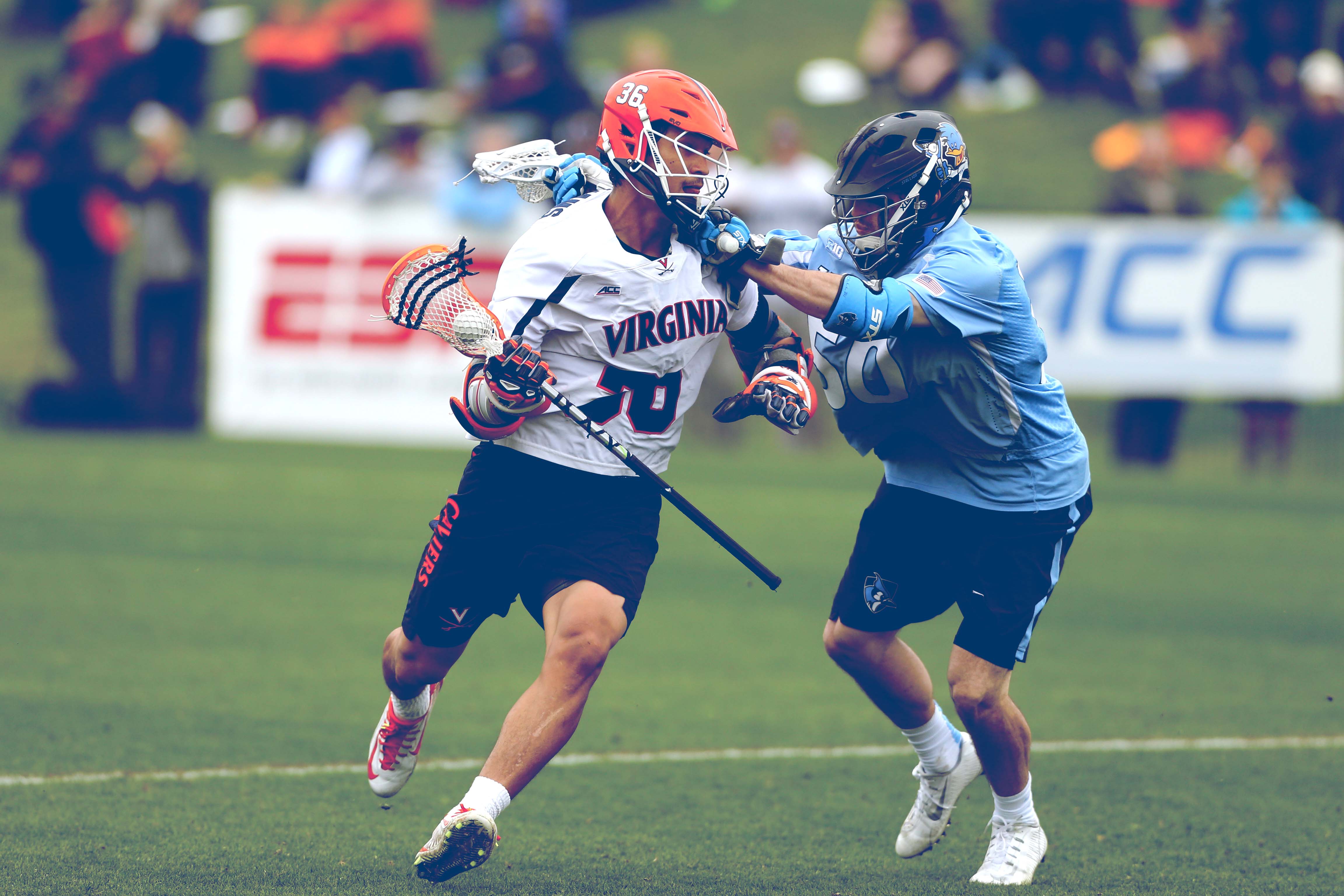 Two Lacrosse players battling on the field during a game