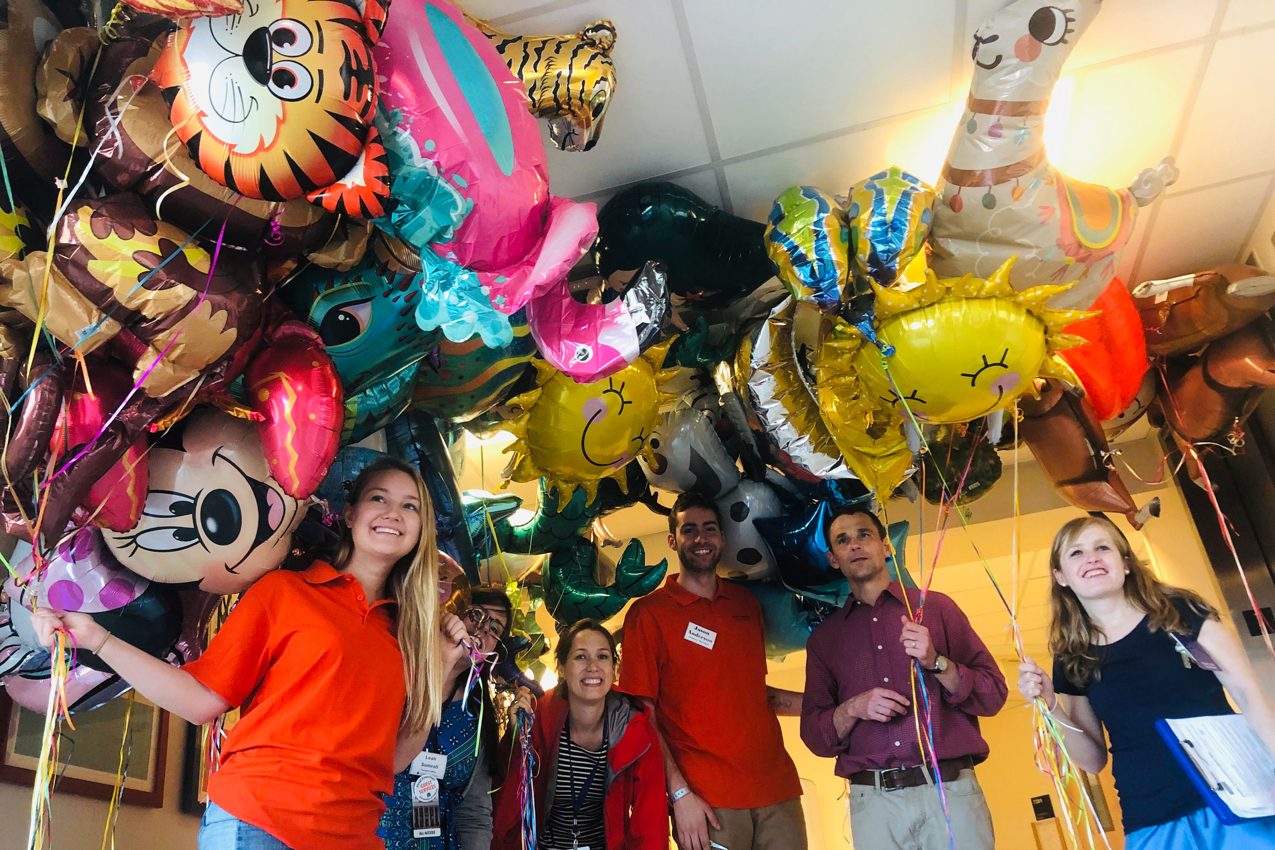 Jim Ryan, second from right, and members of his staff hold the balloons collected at Graduation