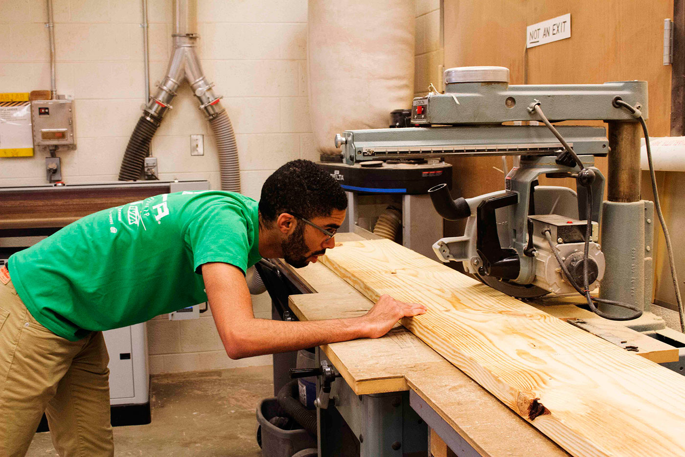 Third-year student Malik Vaughan, a volunteer with Growing for CHANGE, cuts wood for one of the garden boxes. Vaughan volunteered through the National Organization of Minority Architecture Students. (Photo courtesy of Shantell Bingham.) 