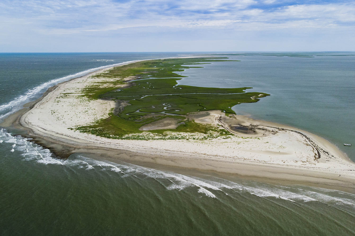 Green and sandy Barrier island surrounded by dark green water