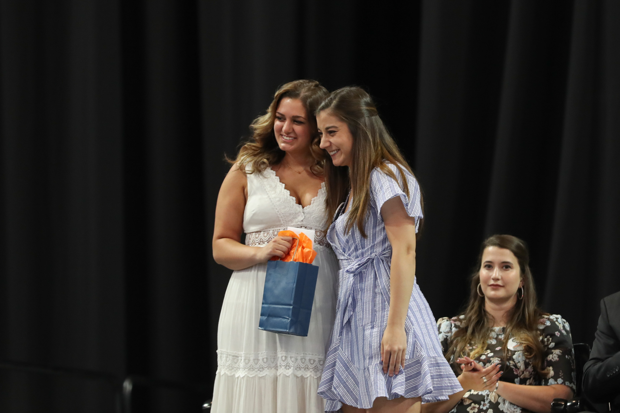 Mariana Brazao, right, and Corinne Singh pose together on stage for a photo