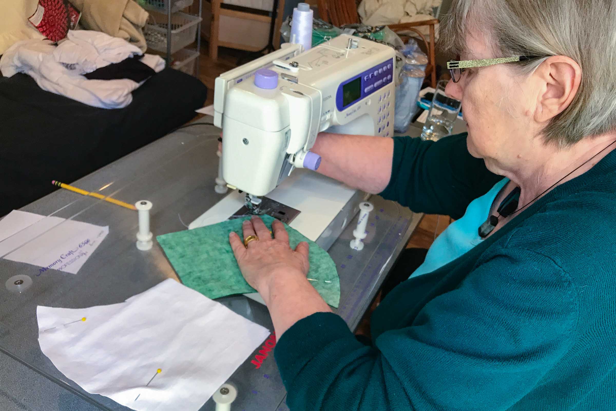 Woman sitting at a sewing machine making a facemask