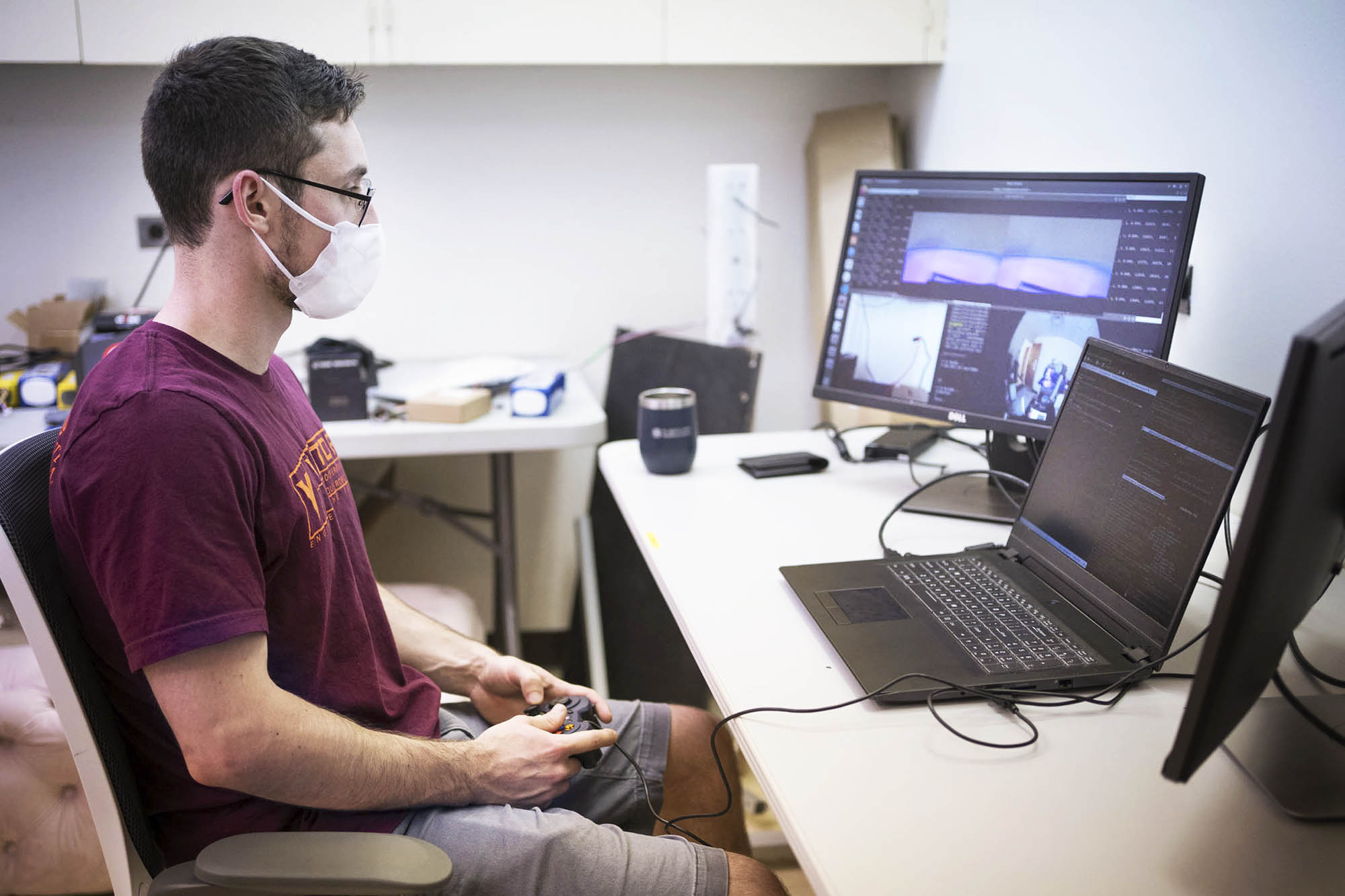 Conte uses a game controller to run a robot through a computer