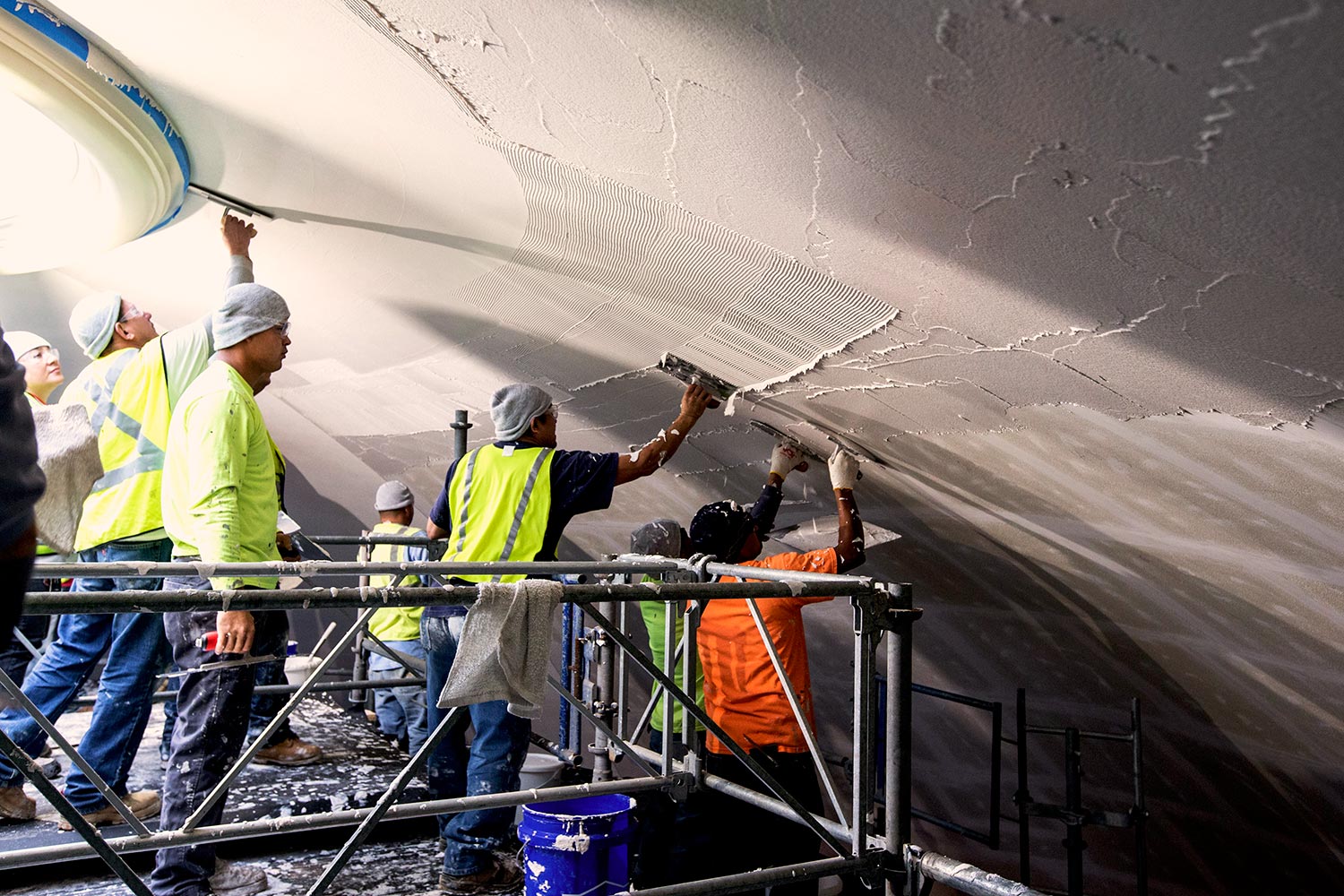 Employees of Interior Specialty Construction, Inc. of Providence Forge, slather plaster on the ceiling of the Rotunda’s Dome Room.