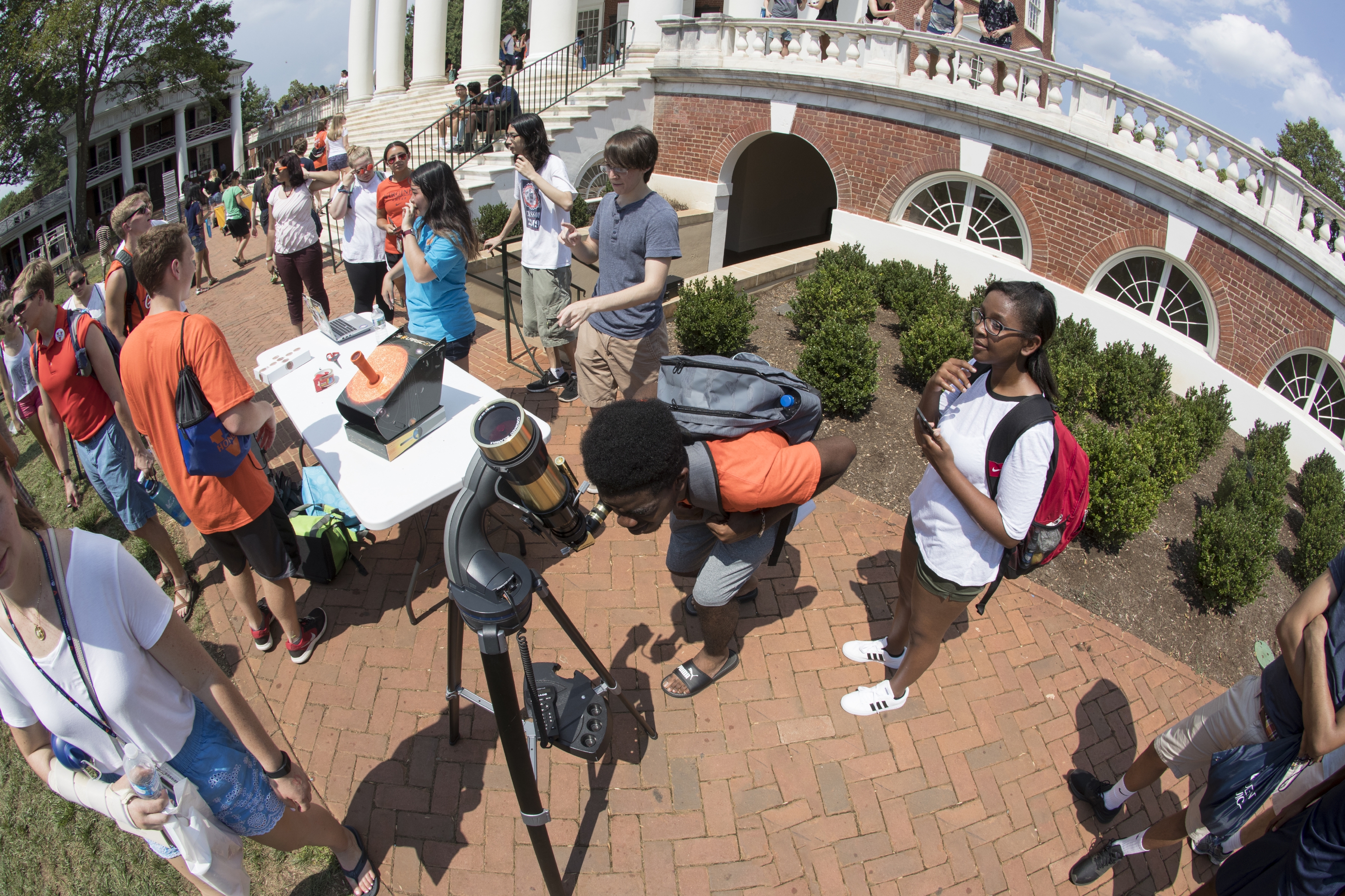 First-year student Emmanuel Ndumbe peers through the H-alpha telescope to see the eclipse
