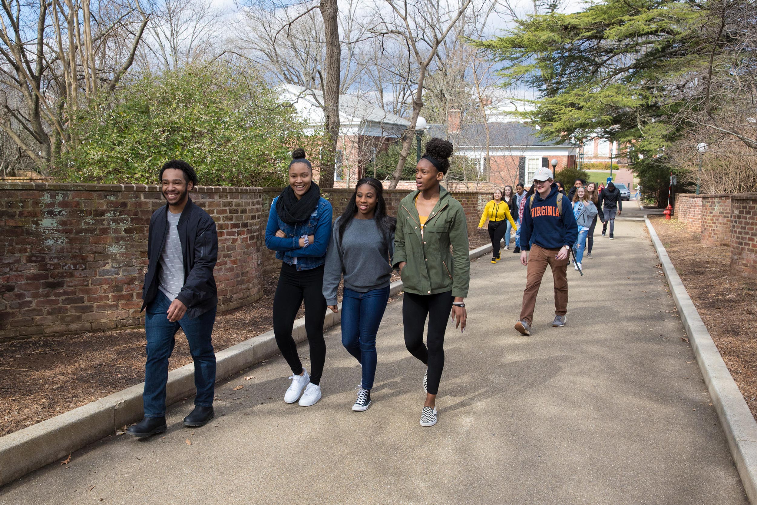Students walking between the serpentine walls near the lawn