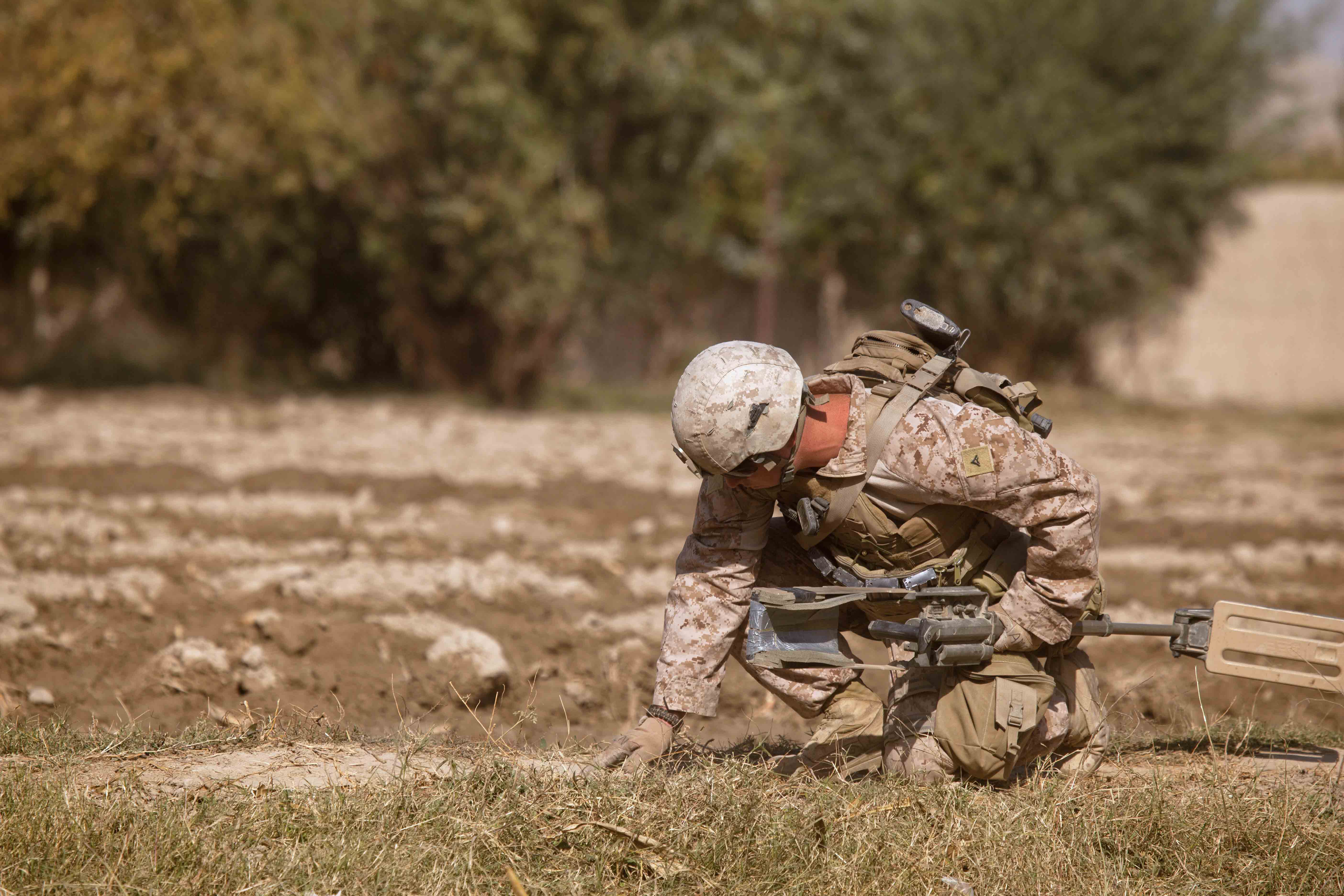India Company’s LCpl Sean Holloway pauses with his metal detector and probes for an IED while on patrol in the Southern Green Zone. (U.S. Marine Corps photo by LCpl Armando Mendoza) 