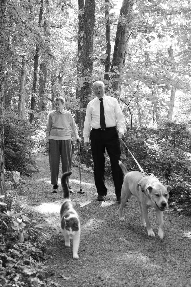 Gillenwater and his wife walking with a dog, black and white image