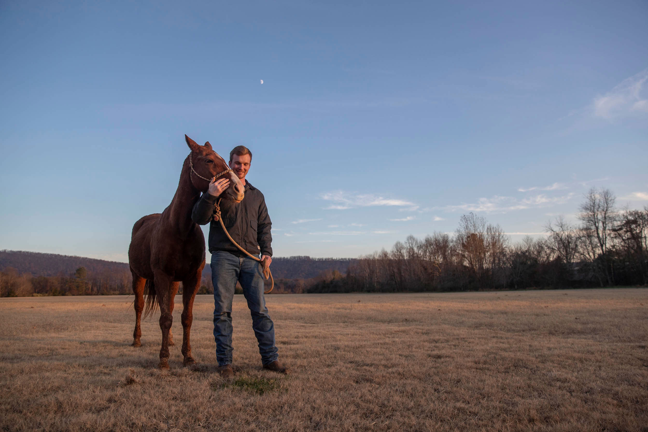 Jake Kausen standing in a field with a Horse