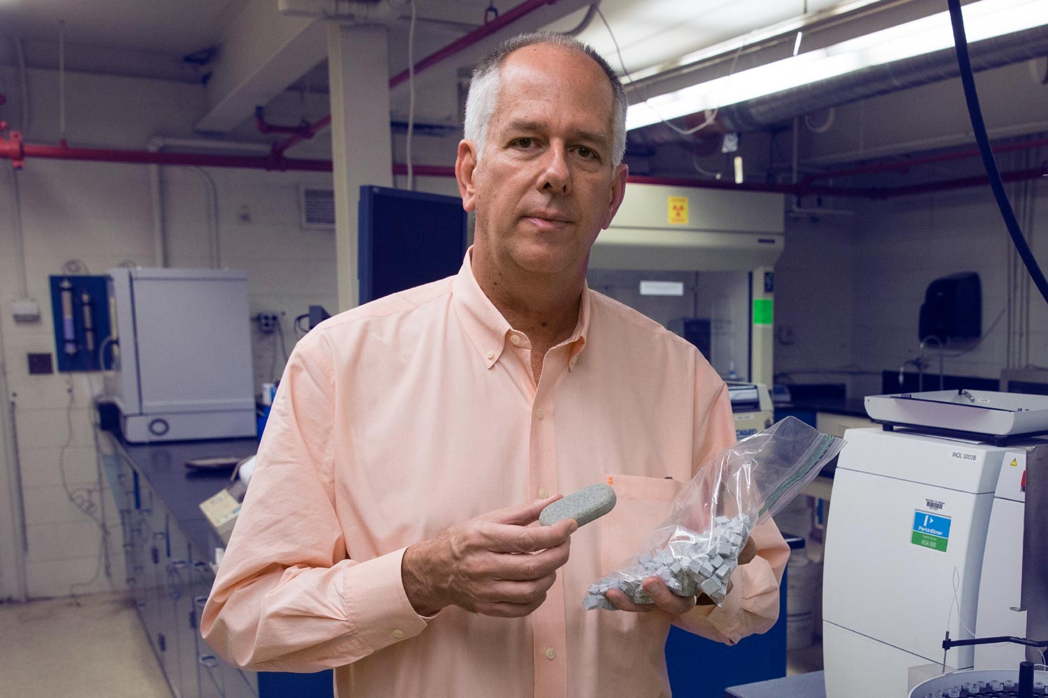 Jim Smith holding the oval MadiDrop tablet in the lab