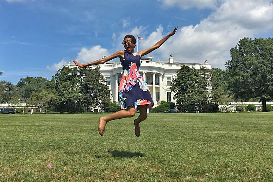 Mims jumps off the White House lawn with the White House behind her