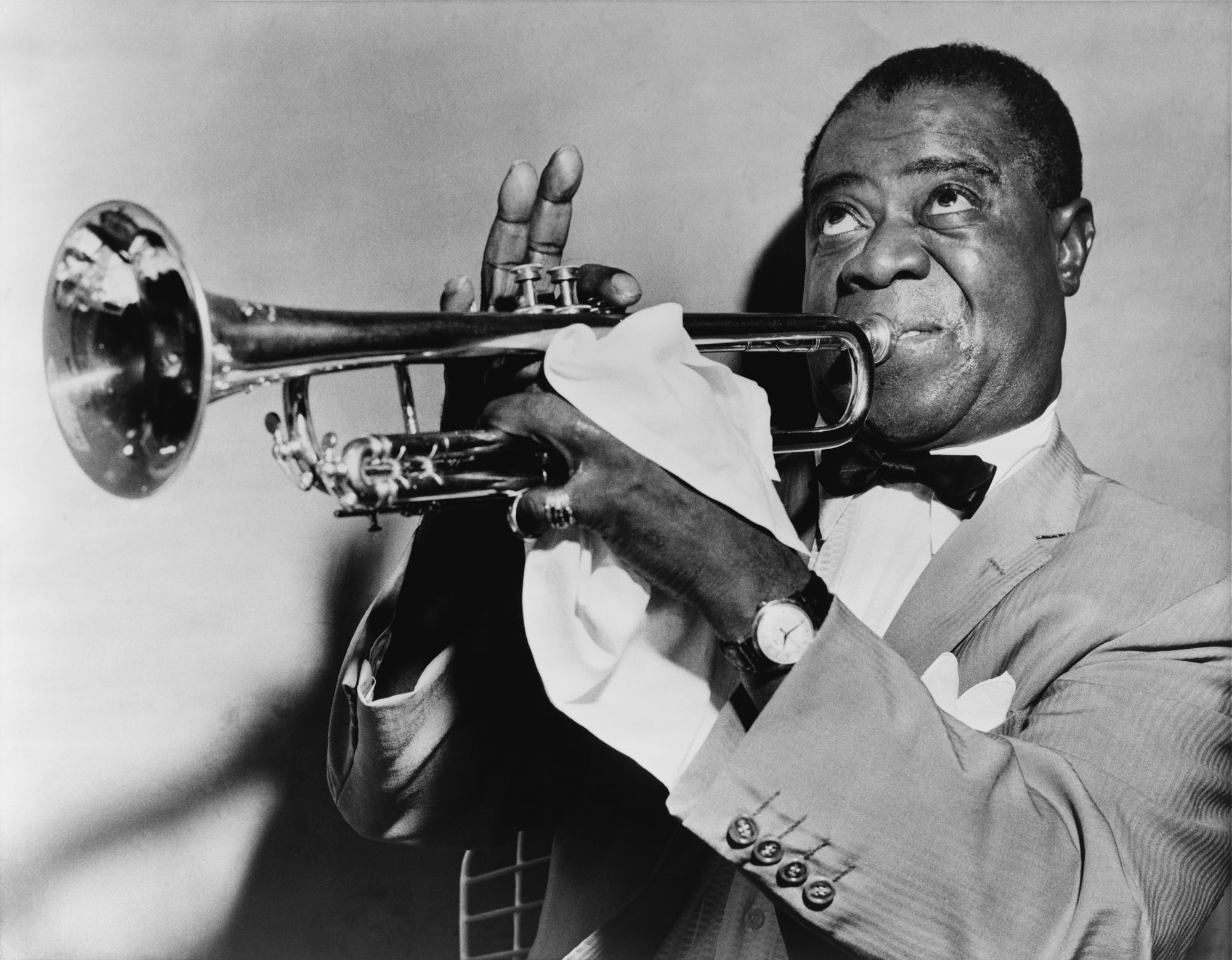 Louis Armstrong playing the trumpet in a black and white photo