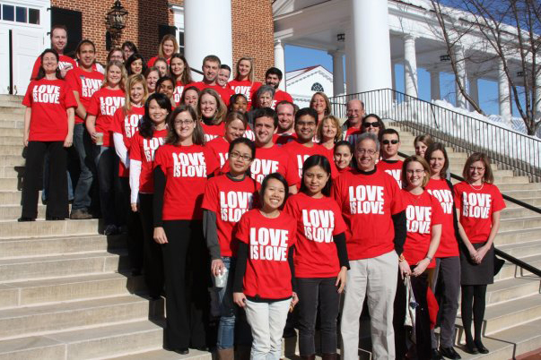 Students stand on steps wearing red shirts that read Love is Love