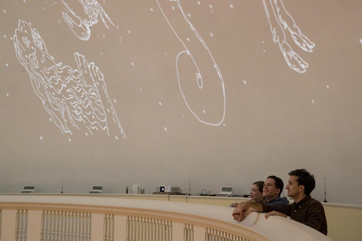 Madeline Zehnder, Neal Curtis and Samuel Lemley stand at the top of the Rotunda dome looking at the constellations