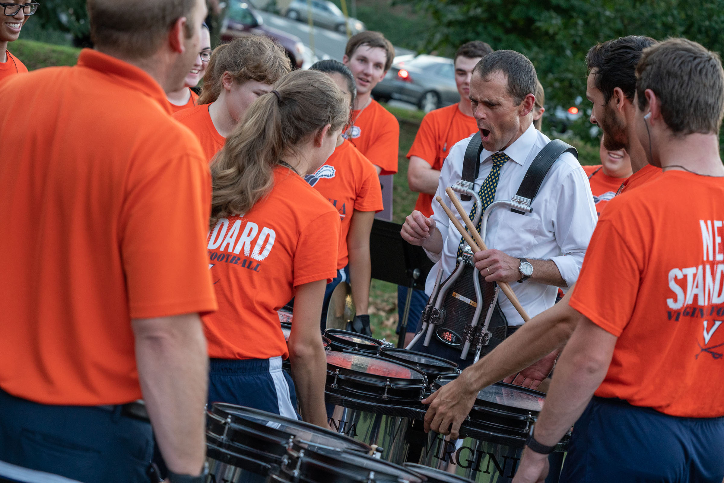 President Jim Ryan carrying a marching band drum while making a face like he is in pain