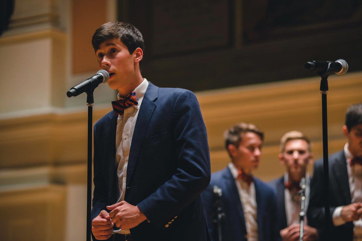 Micah Iverson performs a solo in Old Cabell Hall at a microphone
