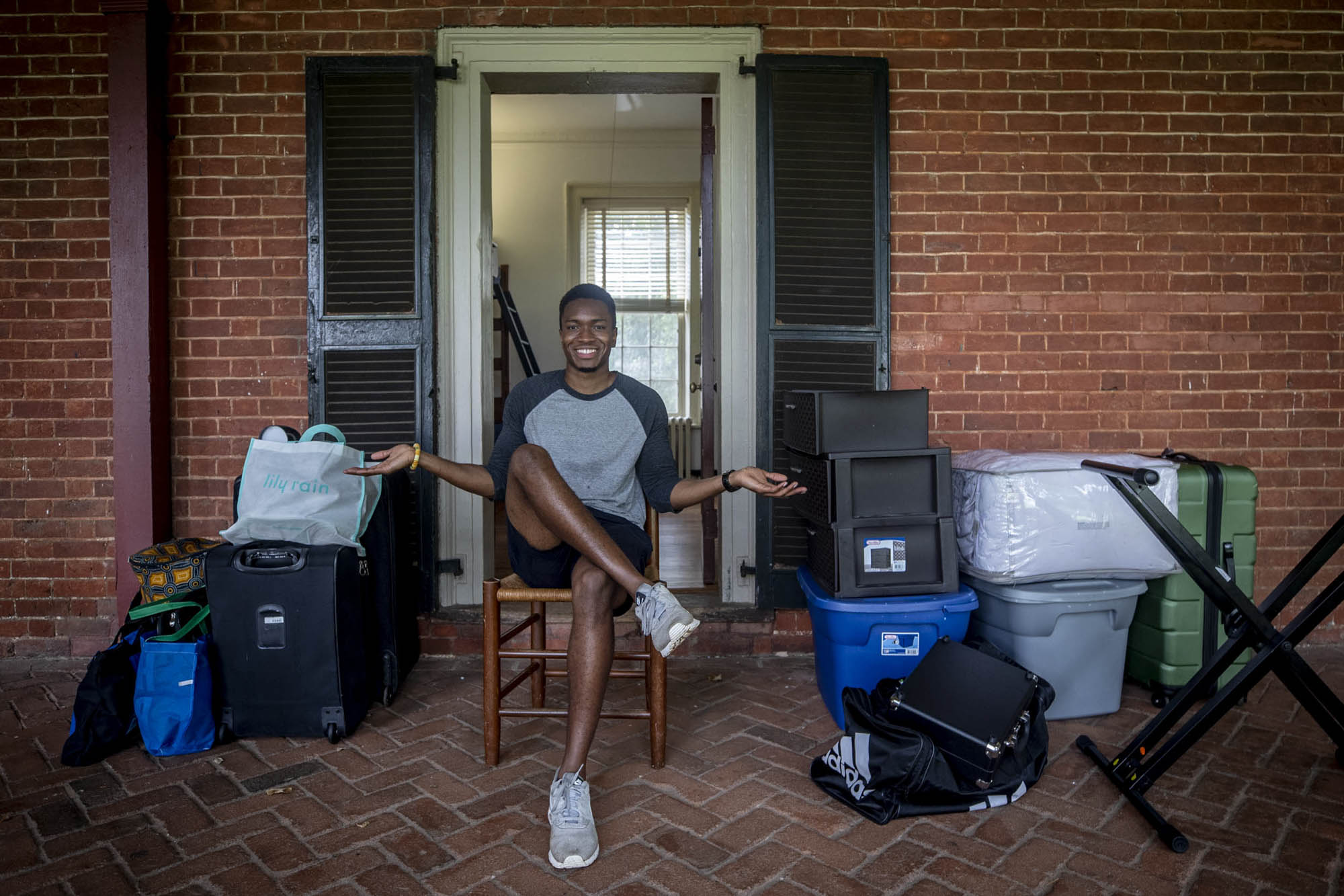 Nathan John sits in front of his room on the Lawn with his personal belongings on the sidewalk before moving in