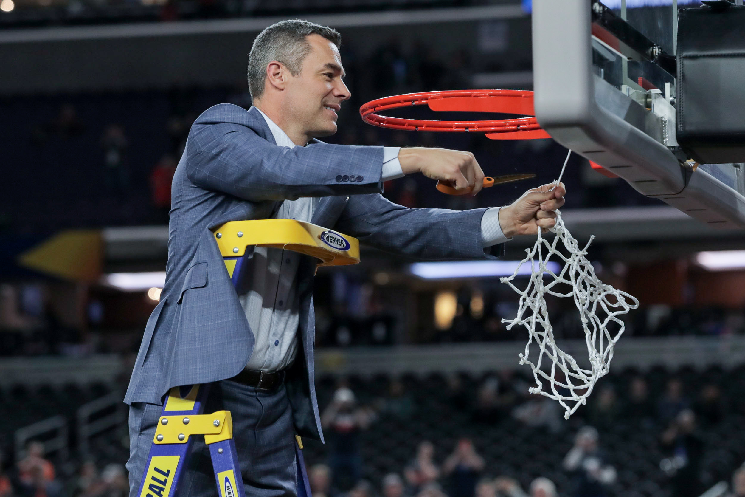 Tony Bennett cutting down the basketball net at NCAA championship