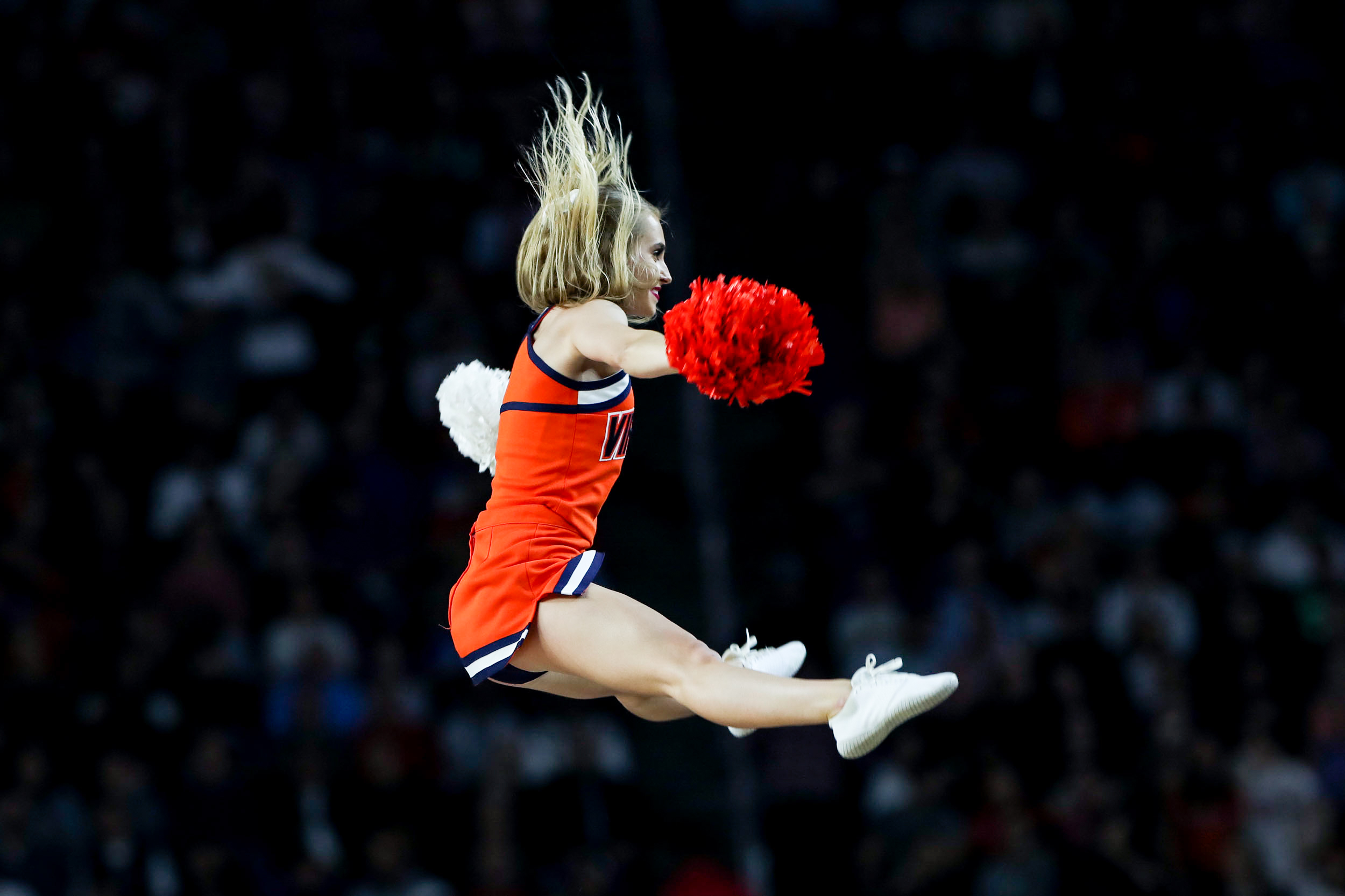 UVA cheer leader doing a straddle jump