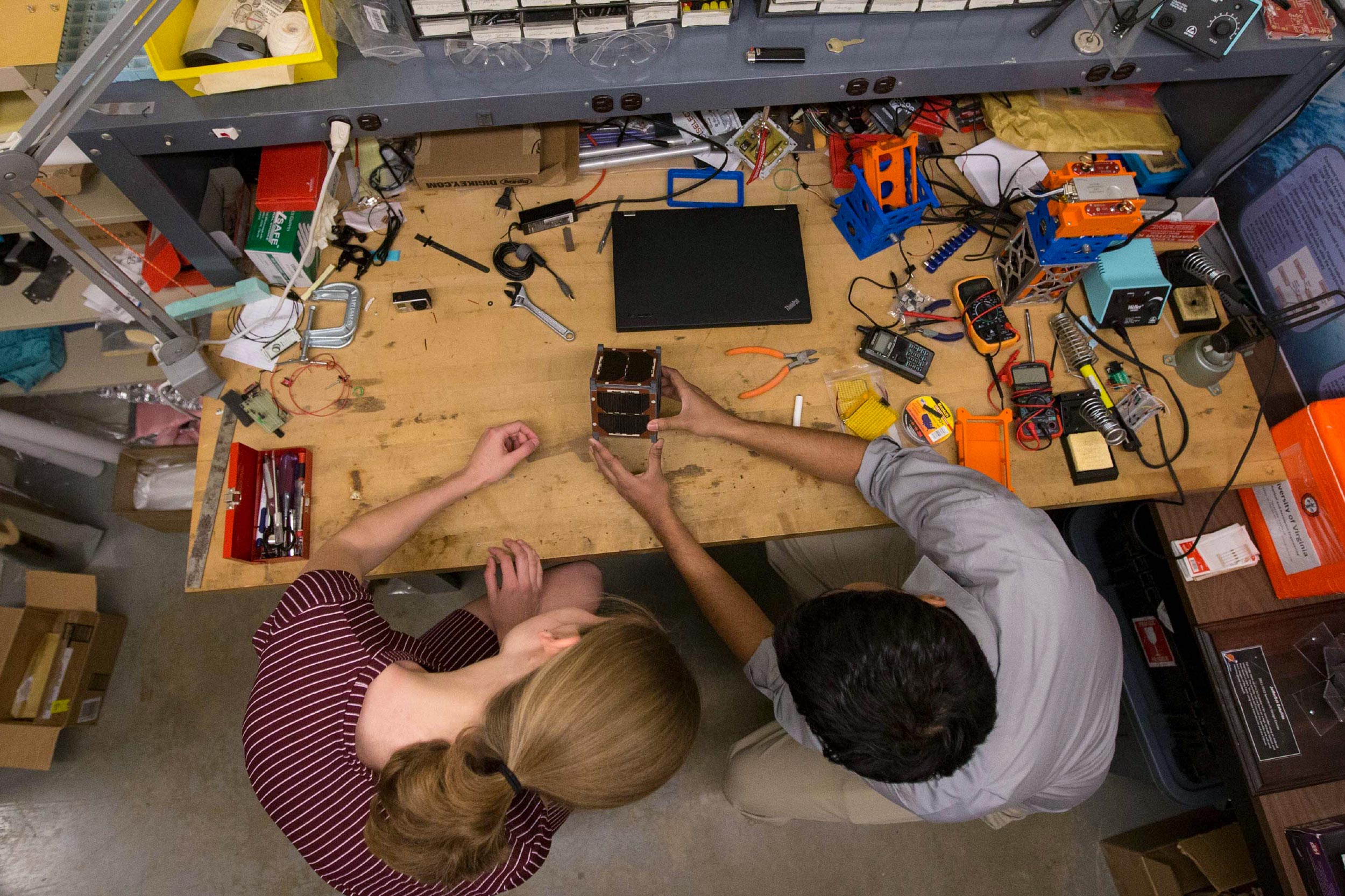  Robin Leiter, left, and Chandrakanth “C.K.” Venigalla, work on an early iteration of UVA’s CubeSat