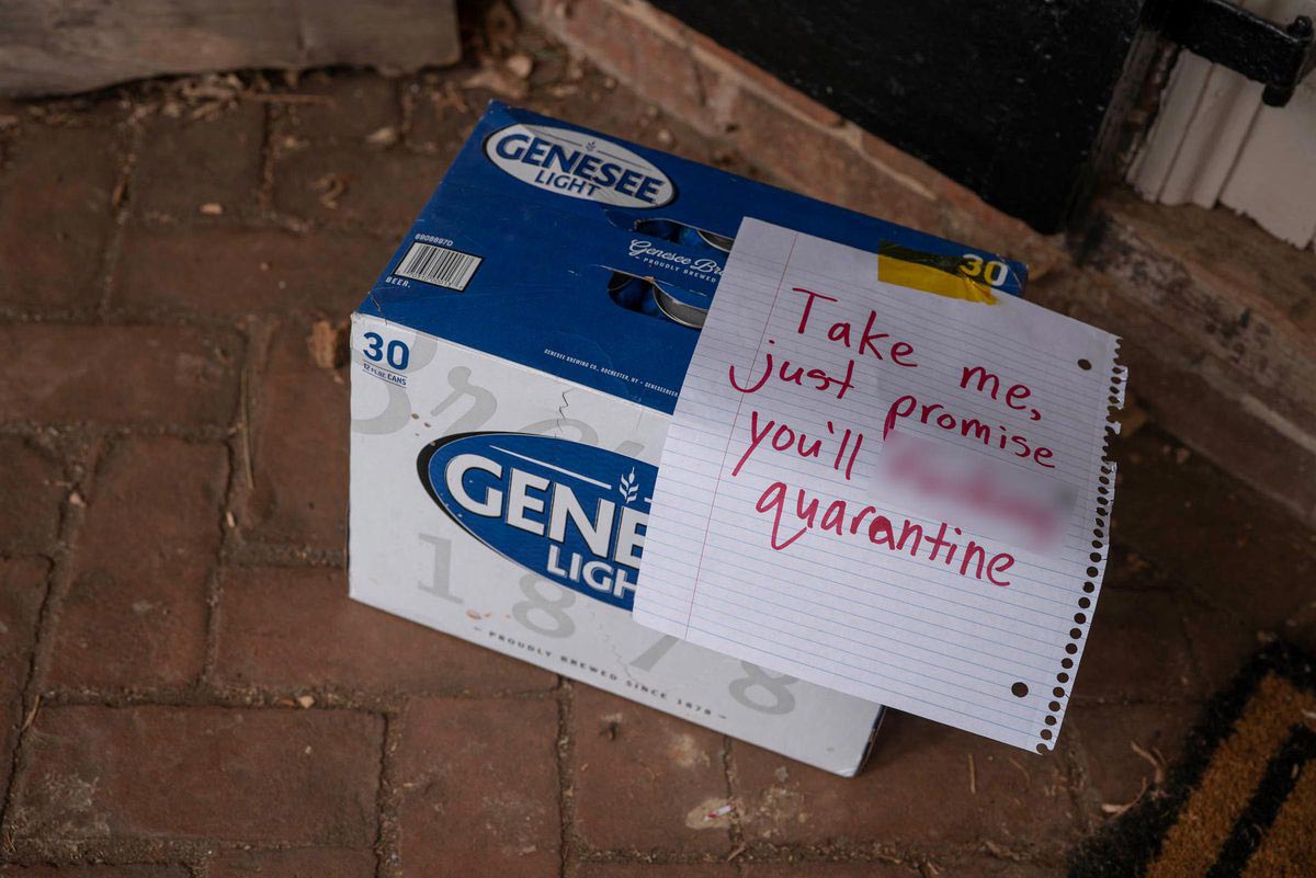30 pack of Genesee Light on the brick sidewalk in front of a Lawn room with a note that read Take me, just promise you'll [expletive blurred out] quarantine