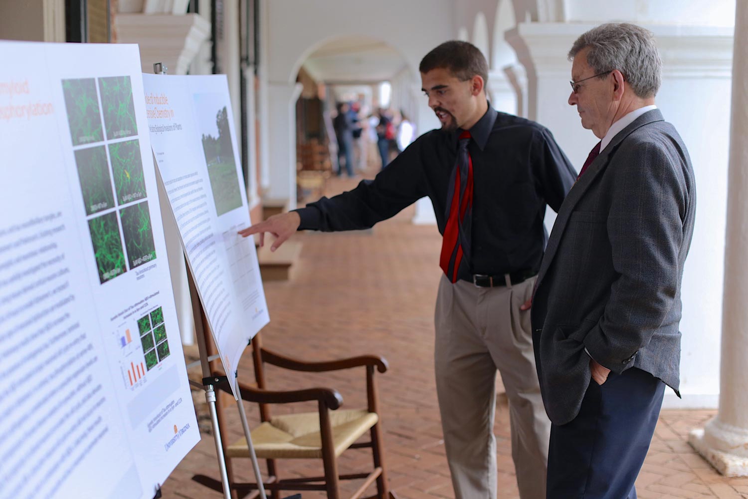 Phil Parrish, right, examining a research poster on display on the Lawn.