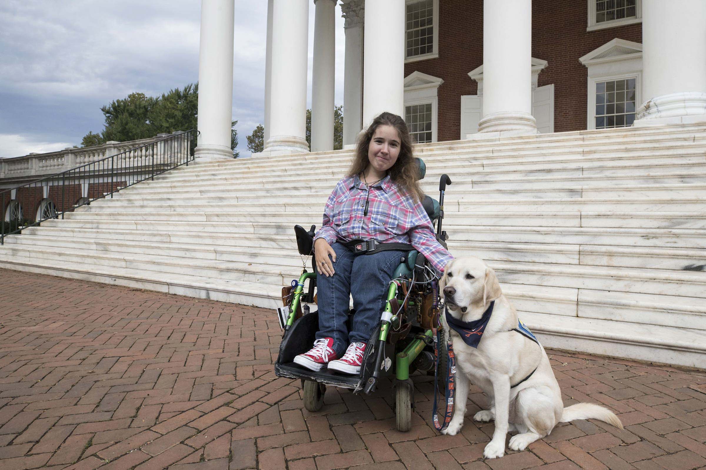 Megale and her service dog Pierre in front of the Rotunda