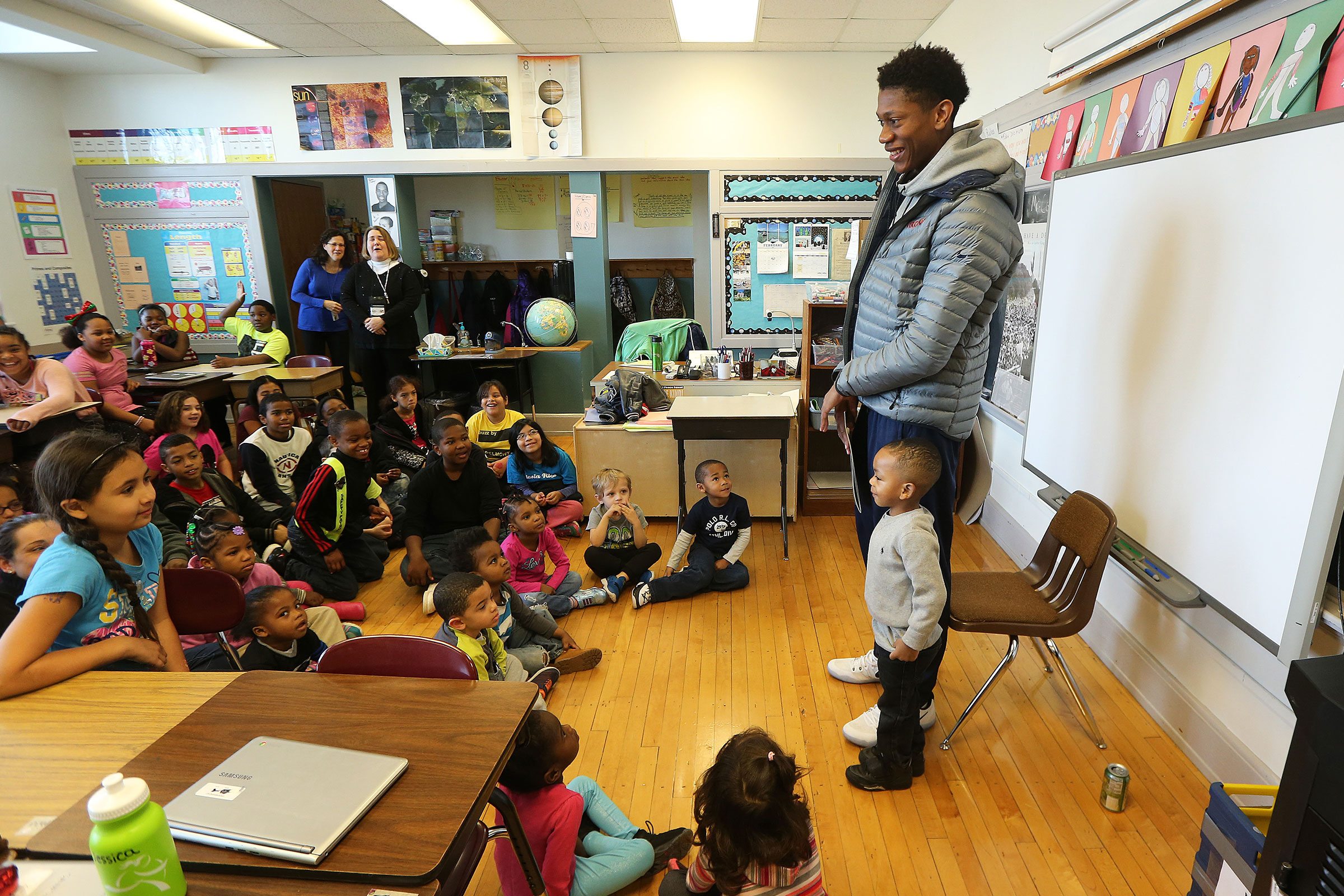 DeAndre Hunter stands in front of a class of small children